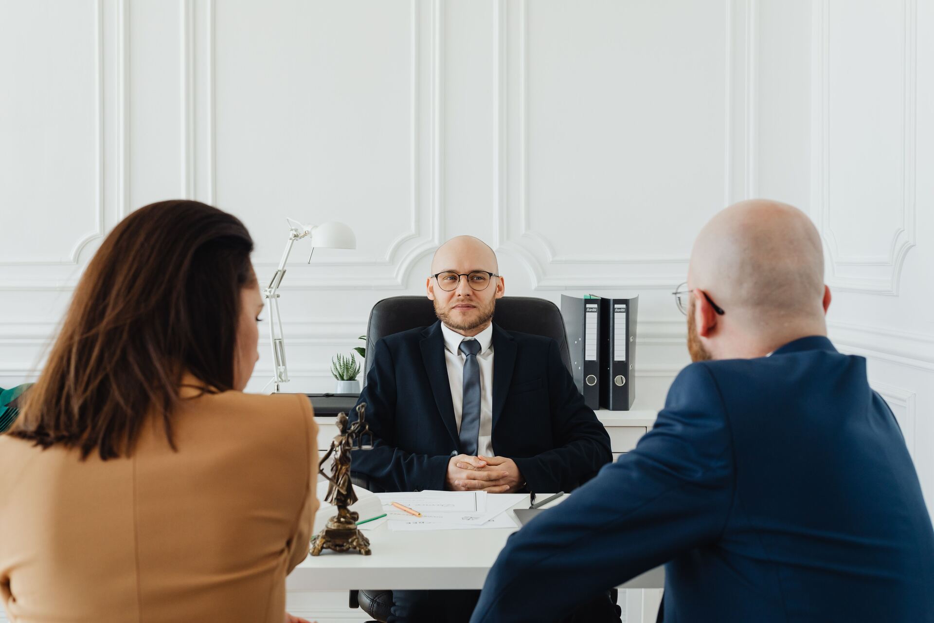 Abogado atendiendo una consulta con clientes en su despacho